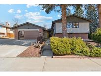 Charming two-story home with brick accents, attached garage, and a well-maintained front yard landscape at 10121 W 70Th Dr, Arvada, CO 80004