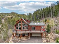 Stunning two-story home featuring a large deck and expansive windows to admire the surrounding mountain forest at 800 Highway 72, Golden, CO 80403