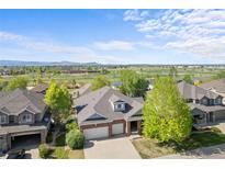 Charming two-story brick home with a well-maintained lawn and mountain views in a peaceful, green neighborhood at 1513 Cannon Mountain Dr, Longmont, CO 80503