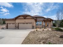 Stucco house with three-car garage and stone accents at 20217 Kenneth Lainer Dr, Monument, CO 80132