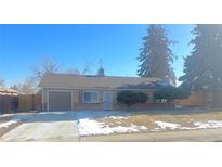 Brick ranch home with attached garage and landscaped yard at 1120 Tucson St, Aurora, CO 80011