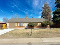 Charming single-story home with a well-maintained front yard and a one car garage at 1120 Tucson St, Aurora, CO 80011