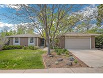 Charming brick home featuring a manicured lawn and beautiful landscaping at 8150 W Calhoun Dr, Littleton, CO 80123
