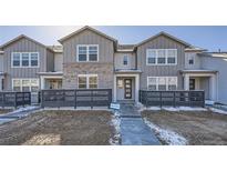 Modern two-story townhome with gray siding, brick accents, and a private fenced yard at 2571 W 69Th Pl, Denver, CO 80221