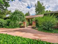Charming home featuring brick walkway, manicured landscaping, and classic architectural details at 6550 E 6Th Avenue Pkwy, Denver, CO 80220