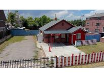 Charming brick house with a red and white picket fence and a spacious parking area at 571 Geneva St, Aurora, CO 80010