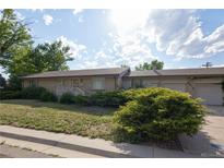 Charming single-story brick home with a well-manicured front yard and a covered front porch at 6579 S Lincoln St, Centennial, CO 80121