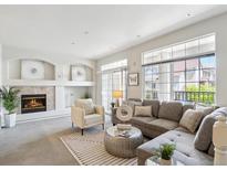 Bright living room with a modern fireplace, grey sofa, and access to a balcony through sliding glass doors at 12711 Colorado Blvd # H804, Thornton, CO 80241