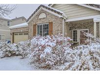 Charming brick home with snow-covered landscaping, adding winter curb appeal at 14931 E 117Th Ave, Commerce City, CO 80603