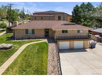Charming ranch-style home with a brick facade, manicured lawn, and convenient two-car garage at 2704 S Ames Way, Denver, CO 80227