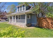 Charming blue two-story home with a stone foundation and inviting front porch at 5101 Meade St, Denver, CO 80221