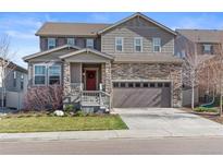 Charming two-story home featuring a stone facade and a welcoming front porch with a red door at 6185 Saddle Bow Ave, Parker, CO 80134