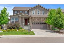 Two-story home featuring stone accents, a covered entry, and a two-car garage at 6185 Saddle Bow Ave, Parker, CO 80134