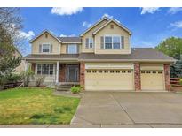 Charming two-story home features a well-manicured lawn and a convenient three-car garage at 4961 Aspen Creek Dr, Broomfield, CO 80023