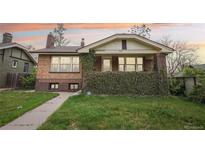 Charming brick home with lush greenery, well-manicured lawn, and inviting curb appeal at 925 S University Blvd, Denver, CO 80209