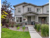 Charming two-story home featuring stone accents, well-manicured landscaping, and a welcoming front porch at 6027 N Netherland Ct, Aurora, CO 80019