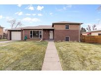 Charming brick home featuring a well-maintained lawn and inviting entryway at 479 S Kendall St, Lakewood, CO 80226