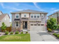 Charming two-story home with a stone-accented entrance, neutral siding, and a well-manicured front yard at 154 Back Nine Dr, Castle Pines, CO 80108