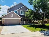 Charming two-story home with a well-maintained front yard and a two car attached garage at 1744 Brookside Dr, Highlands Ranch, CO 80126