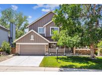 Charming two-story home featuring a well-maintained front yard with beautiful tree and a two-car garage at 1744 Brookside Dr, Highlands Ranch, CO 80126