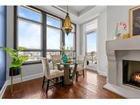 Bright dining area featuring a modern table set, fireplace, and expansive windows with city views at 5455 Landmark Pl # 815, Greenwood Village, CO 80111