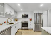 This is a kitchen with stainless steel appliances and bright white cabinets at 13631 E Marina Dr # 105, Aurora, CO 80014
