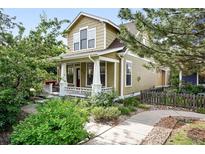 Charming two-story home features a covered front porch and lush landscaping at 9134 E 29Th Pl, Denver, CO 80238