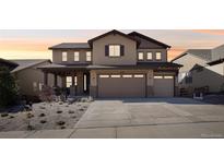 Charming two-story home with a three-car garage and covered porch at 18984 W 85Th Blf, Arvada, CO 80007