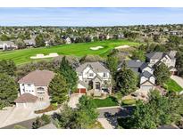 Stately home overlooks a golf course in a vibrant community with mature trees and blue skies at 7120 Forest Ridge Cir, Castle Pines, CO 80108