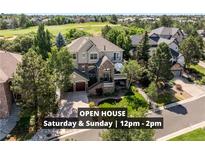 Inviting home featuring a stone facade, a private balcony, an attached garage, and mature landscaping at 7120 Forest Ridge Cir, Castle Pines, CO 80108