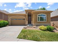 Attractive single-story home featuring a two-car garage, arched window and manicured lawn at 11645 Colony Loop, Parker, CO 80138
