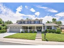 Two-story home featuring a spacious front yard, covered porch, and attached garage at 3843 S Quince St, Denver, CO 80237