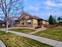 Charming single-story home with stone accents, well-maintained lawn, and inviting curb appeal at 6544 S Millbrook Way, Aurora, CO 80016