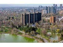Stunning aerial view of Denver apartment buildings with lake and city skyline, showing surrounding park and walking trails at 460 S Marion Pkwy # 1351, Denver, CO 80209