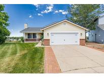 Charming single-Gathering home featuring a manicured lawn and an attached two-car garage with white doors at 551 Snowy Owl Pl, Highlands Ranch, CO 80126
