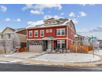 Charming two-story home with red siding, stone accents, and a well-maintained front yard in winter at 23593 E Chenango Pl, Aurora, CO 80016