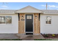 Home exterior featuring a black front door, new wood trim, and manicured landscaping at 1130 Orchard St, Golden, CO 80401
