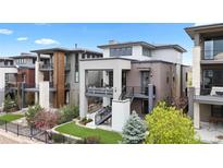 Modern three-story home with outdoor balconies, manicured lawn, and professional landscaping at 10113 Bellwether Ln, Lone Tree, CO 80124