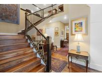 Elegant foyer features a staircase with wood treads, iron spindles, and views into formal living spaces at 1995 Wingfeather Ln, Castle Rock, CO 80108
