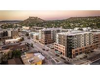 Stunning aerial view captures the urban setting with modern apartments and distant mountain scenery at 20 Wilcox St # 318, Castle Rock, CO 80104