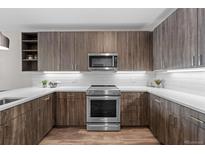 Modern kitchen with stainless steel appliances, sleek cabinets, white countertops and wood flooring at 20 Wilcox St # 318, Castle Rock, CO 80104