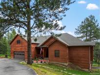 Inviting exterior view of the home featuring a beautiful yard and wood siding at 28465 Cragmont Dr, Evergreen, CO 80439