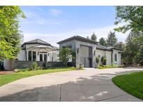 Elegant home with a circular driveway, gray stone portico, and manicured landscaping at 96 Glenmoor Ln, Cherry Hills Village, CO 80113