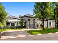Stunning home exterior featuring manicured landscaping, a stylish gated entry, and a circular driveway at 96 Glenmoor Ln, Cherry Hills Village, CO 80113