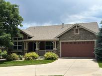 Charming single-Gathering home featuring stone accents, a well-manicured lawn, and an attached two-car garage at 5810 Moss Ct, Golden, CO 80403