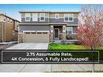 Charming two-story home featuring stone accents, a well-manicured lawn, and a two-car garage at 9283 Sedalia St, Commerce City, CO 80022