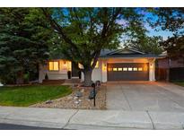Charming single-story home with mature trees, a two-car garage, and attractive landscaping at 13693 W Utah Cir, Lakewood, CO 80228