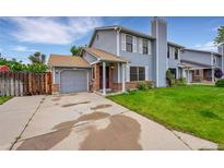 Charming home with a two-car garage, beautiful lawn, traditional siding, and brick accents at 5275 Cody St, Arvada, CO 80002