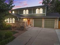 Charming two-story home featuring a brick facade, a well-manicured lawn, and an attached two-car garage at 11039 W 65Th Way, Arvada, CO 80004