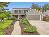 Charming two-story home with landscaped yard, beautiful flowerbeds, and a two-car garage at 7708 S Krameria Ct, Centennial, CO 80112